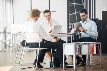 a group of corporate team members discussing their top considerations when selecting a new CPM platform